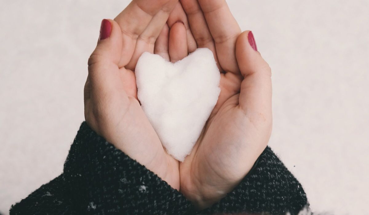 two hands holding a snow-shaped heart
