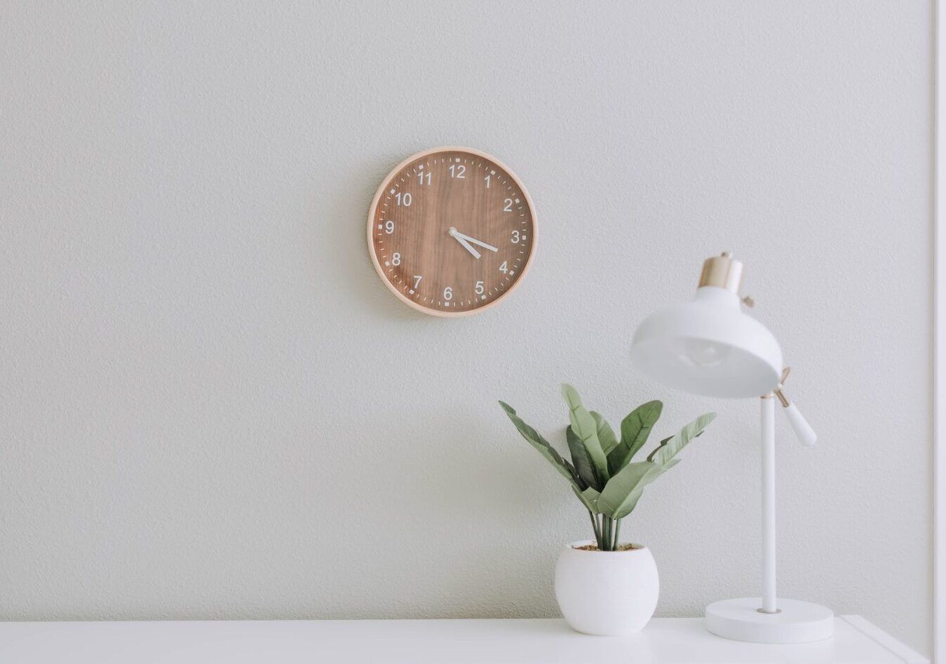 4 approaches to time management desk with clock above and plant