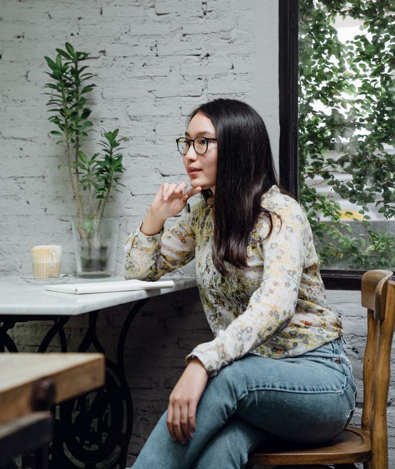 An asian female New York expert therapist sitting in chair at table