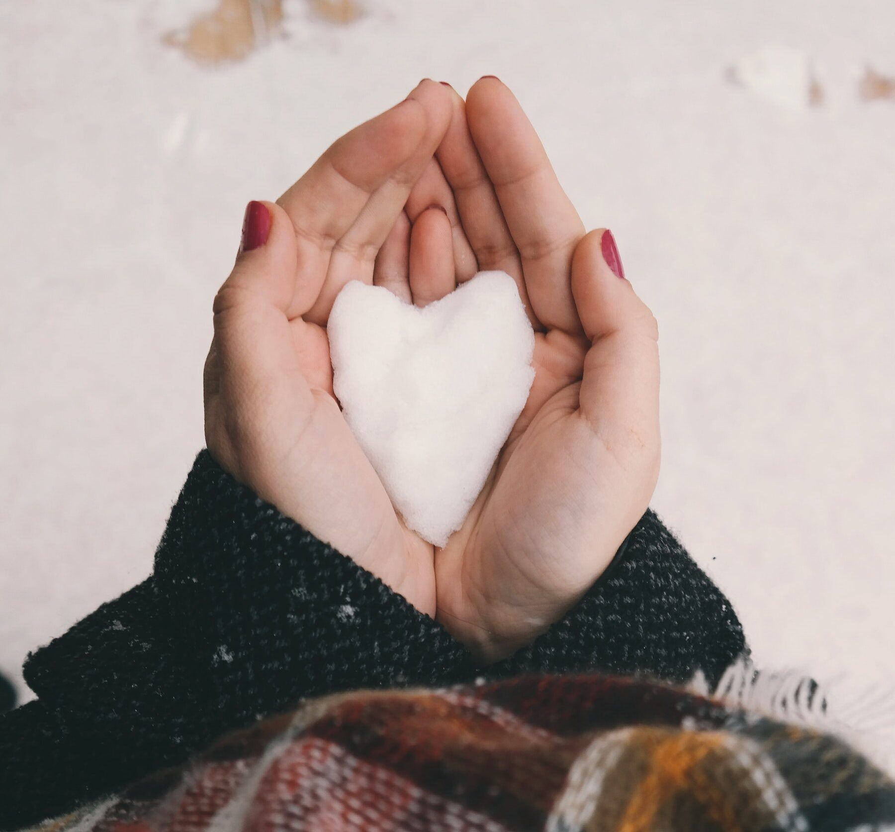 two hands holding a snow-shaped heart