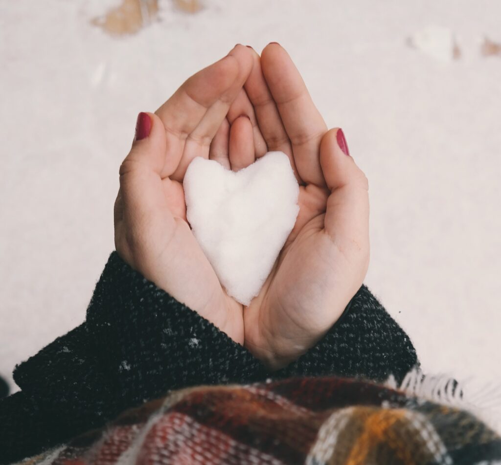 two hands holding a snow-shaped heart